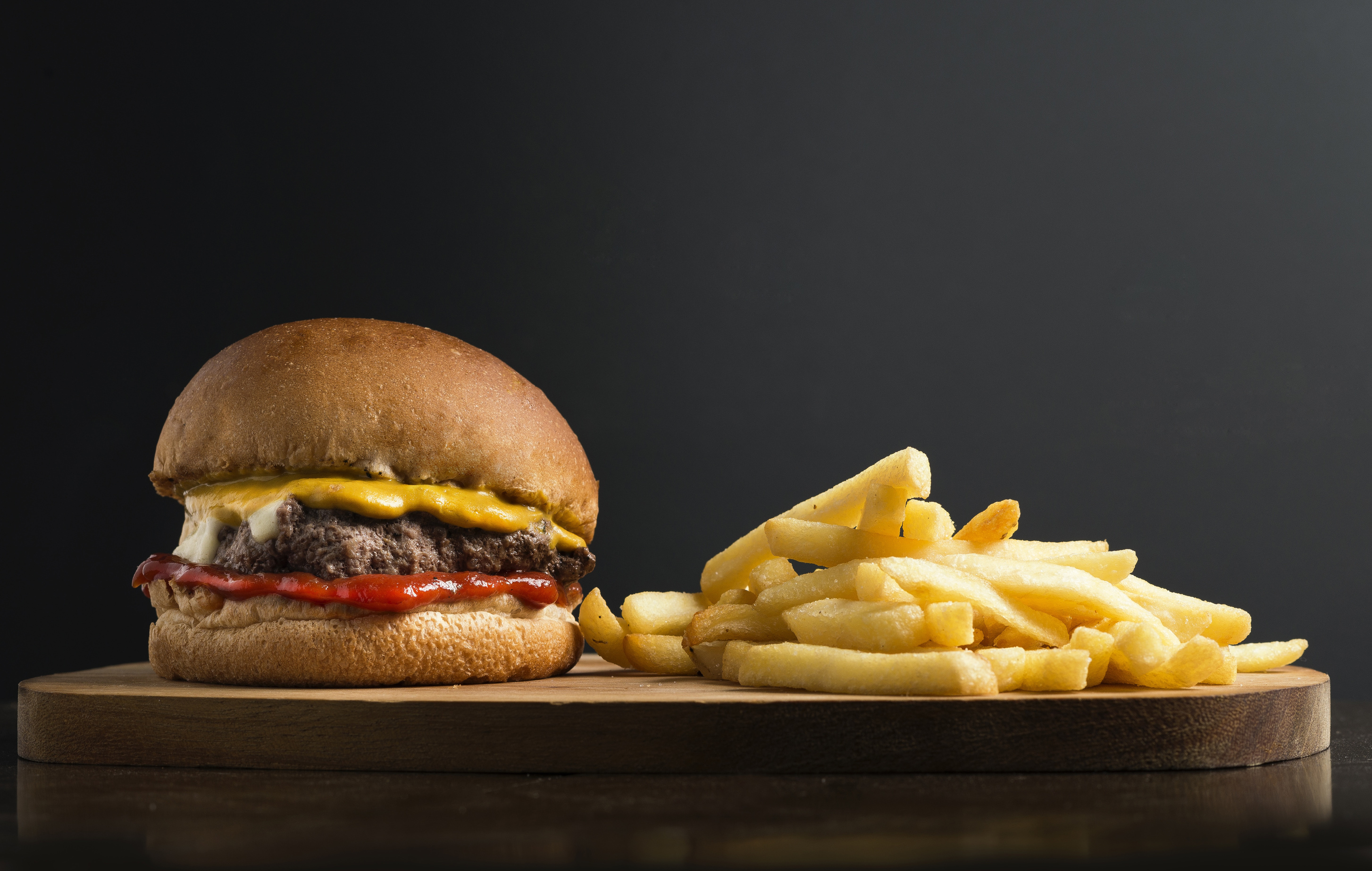 Cheeseburguer and French Fries on Black Background